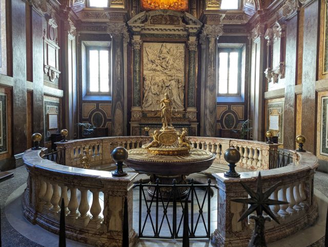 The interior of the baptistery within the Papal Basilica di Santa Maria Maggiore in Rome, Italy, showcasing the central baptismal font, and other architectural details.