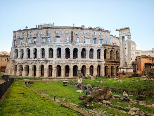 The Teatro di Marcello (Theatre of Marcellus) in Rome, Italy, an ancient Roman theatre with a distinctive semicircular design, featuring arched openings on the lower level, later additions of residential apartments above, and visible ruins of the original structure.